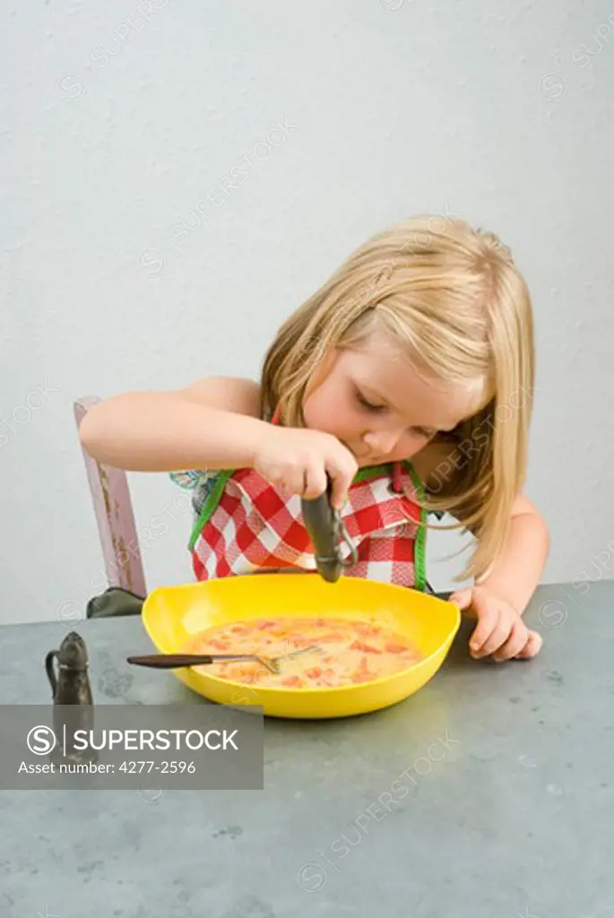 Little girl seasoning food