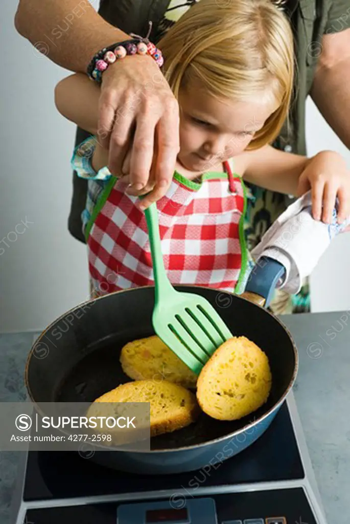 Little girl preparing food with adult