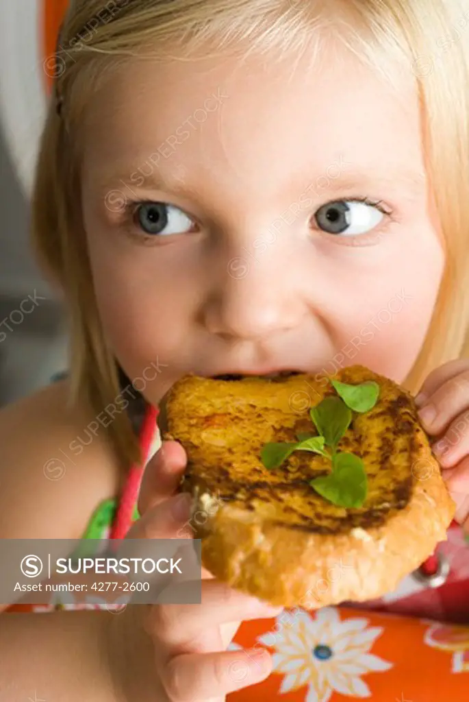 Little girl eating toasted bread