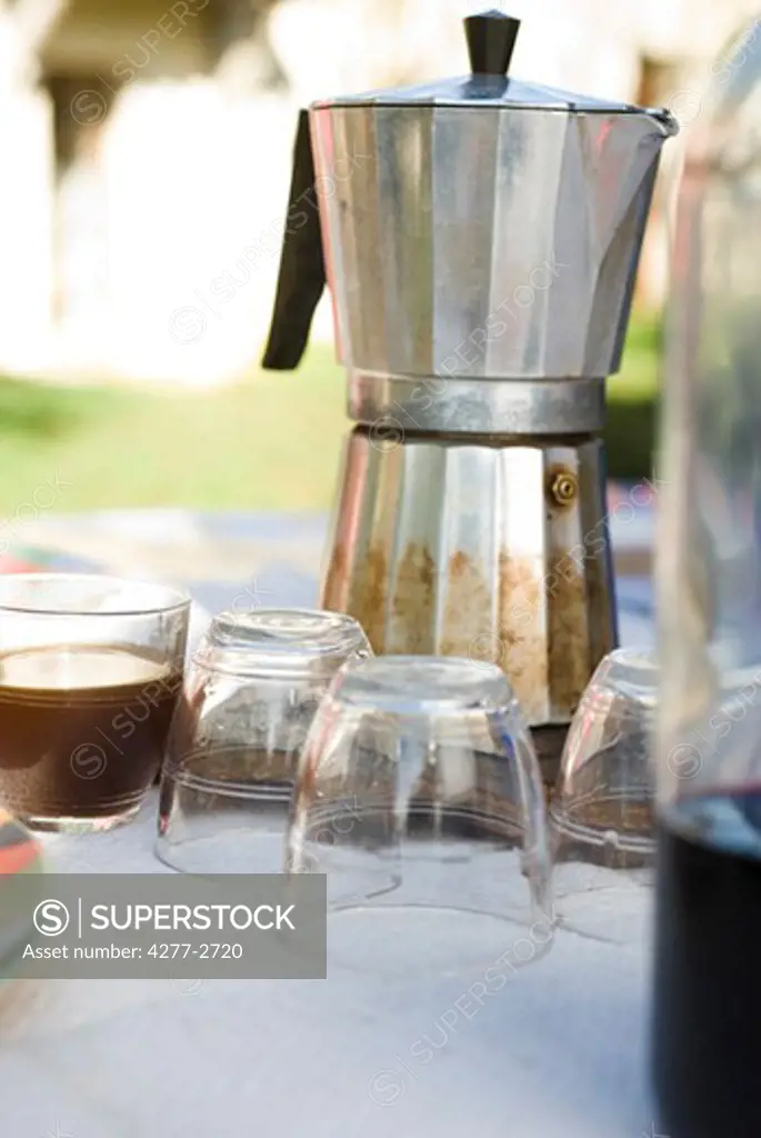 Espresso maker and glasses on outdoor table