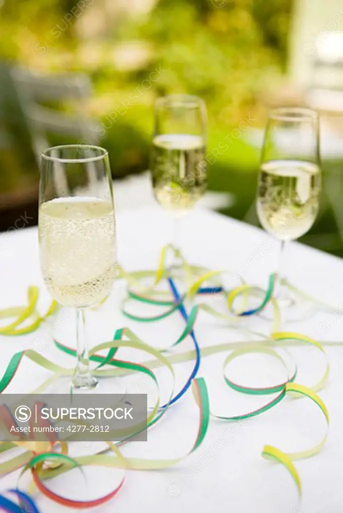 Champagne flutes on table decorated with party streamers