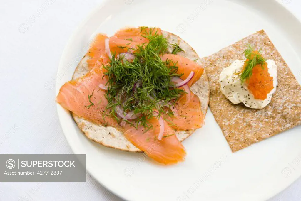 Crisp bread topped with smoked salmon and fresh dill, sour cream and salmon roe
