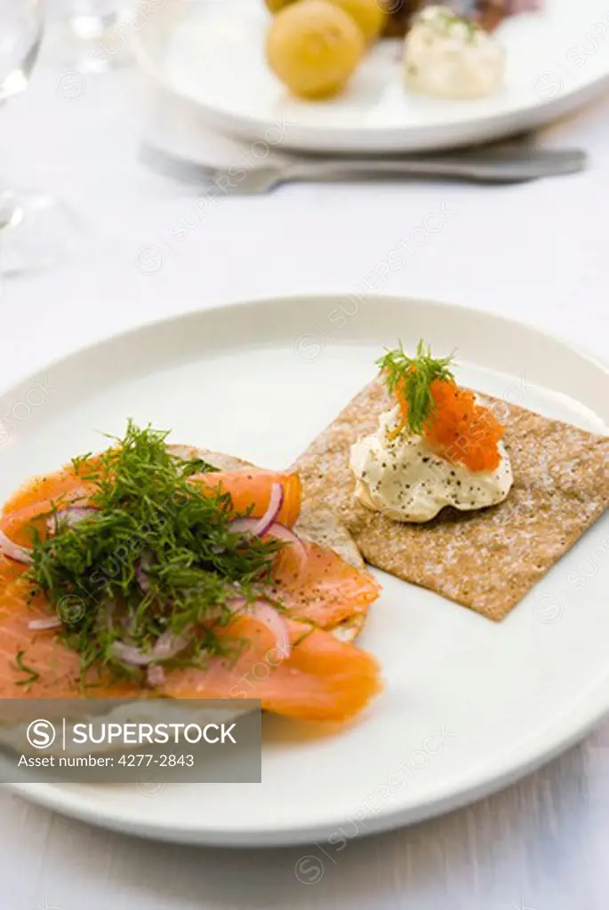 Crisp bread topped with smoked salmon and fresh dill, sour cream and salmon roe