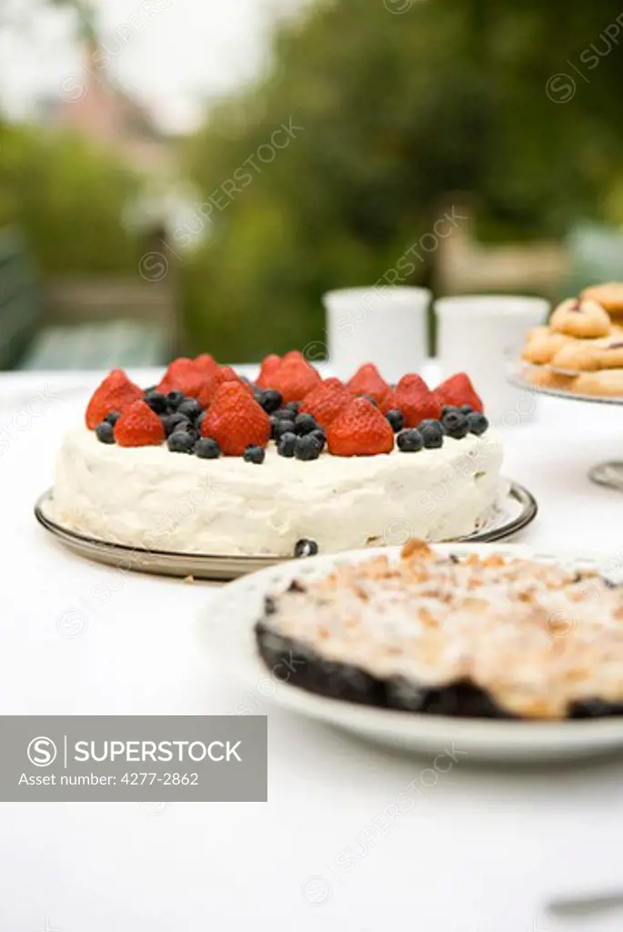 Strawberry blueberry cake and blueberry crumble on dessert table