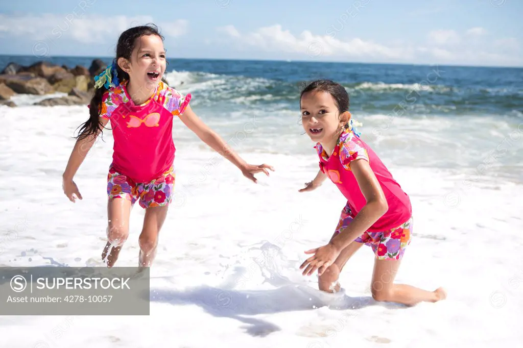 Twin Girls in Matching Outfits Playing on Beach