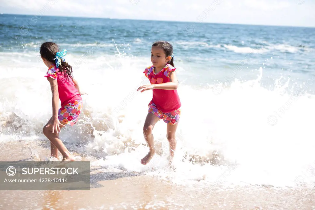 Twin Girls in Matching Outfits Playing on Beach