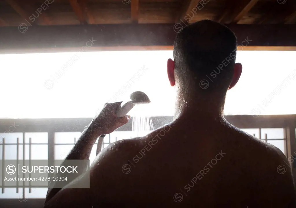 Back View of Man Taking Shower Outdoors