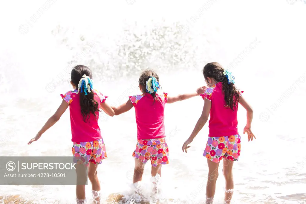 Back View of Girls in Matching Outfit Walking into the Sea