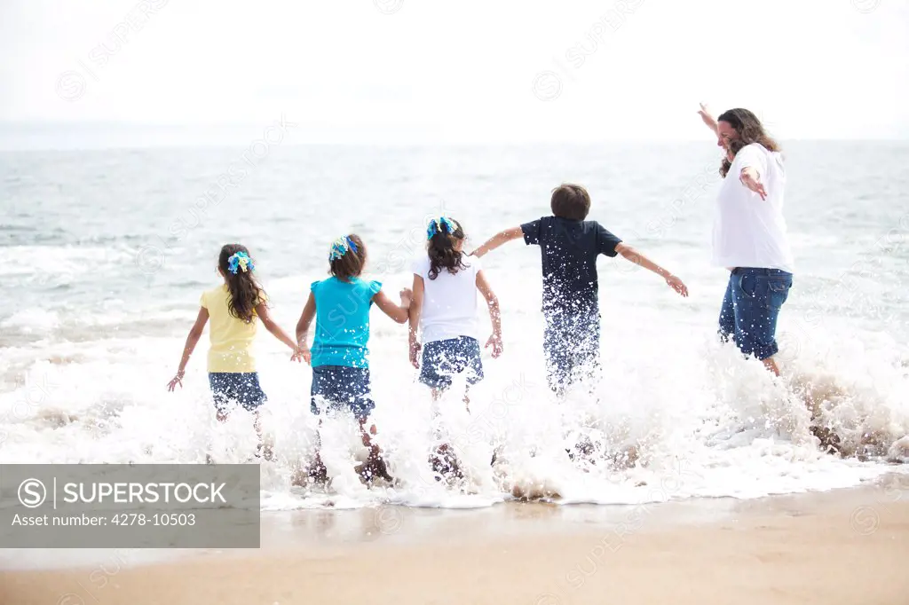 Back View of Family Running into the Sea