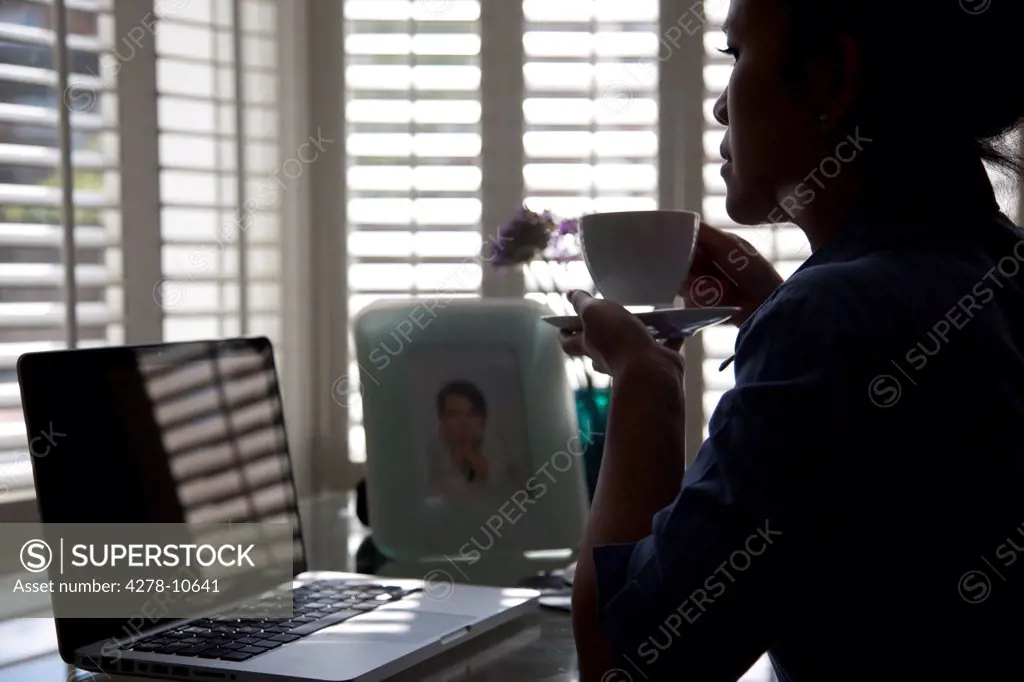 Woman Sitting at Desk Having Coffee