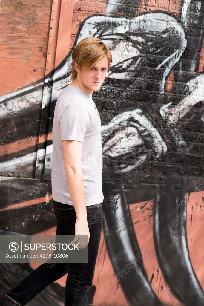 Man Walking by Graffiti Wall