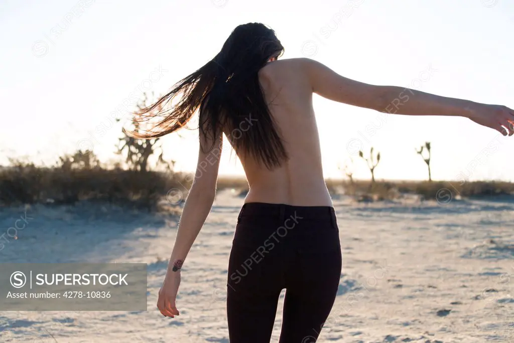 Back View of Woman Strolling on Beach