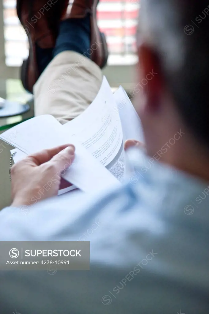 Man with Feet Up Checking Documents