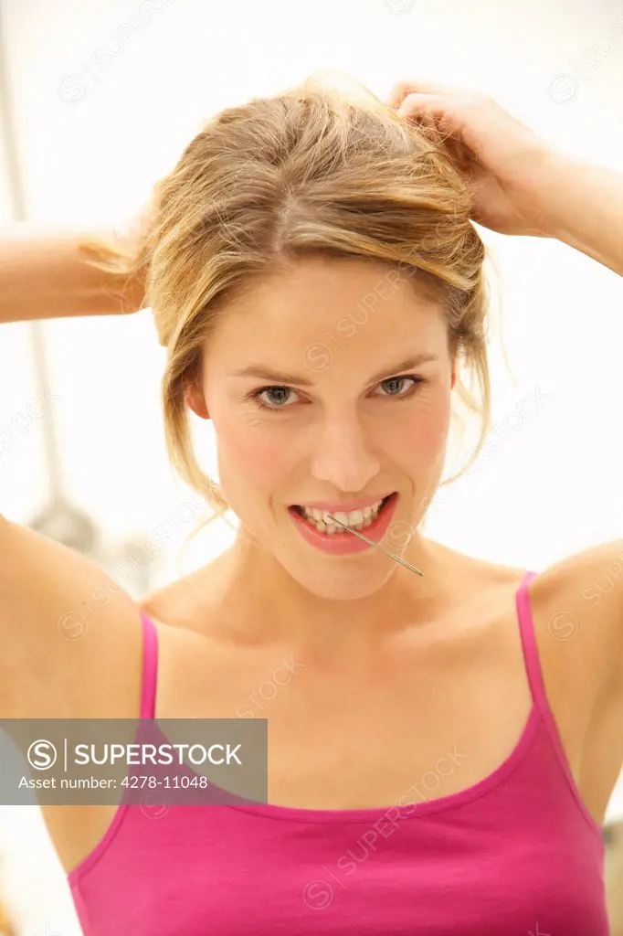 Woman Adjusting Hair with Hairpin in Mouth