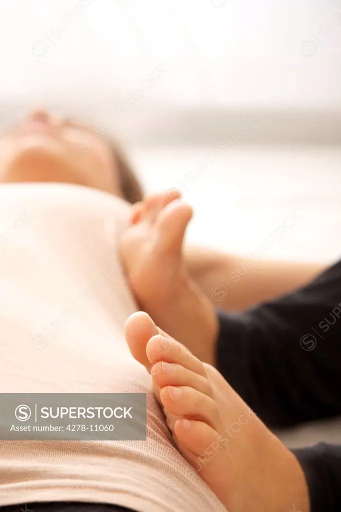 Massage Therapist's Feet on Woman's Body