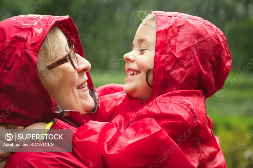 Grandmother and Granddaughter Hugging in the Rain