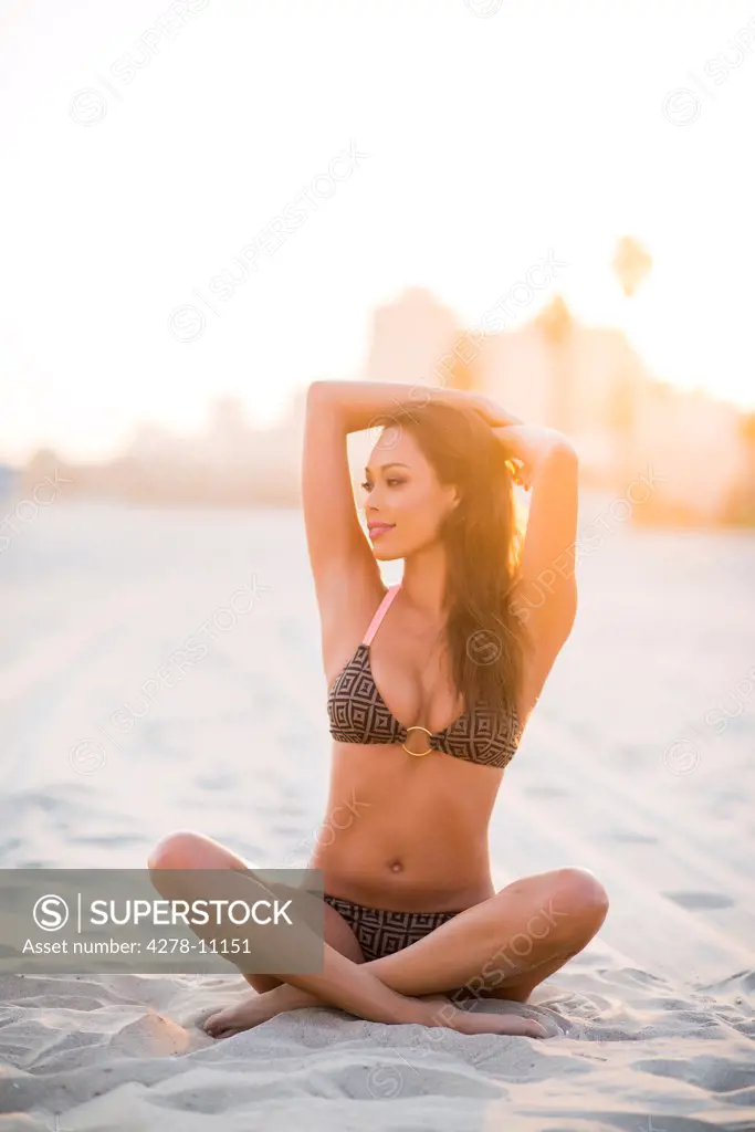 Woman on Beach with Arms Behind Head