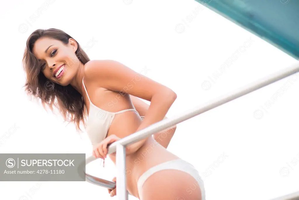 Smiling Woman Wearing Bikini Leaning on Railing