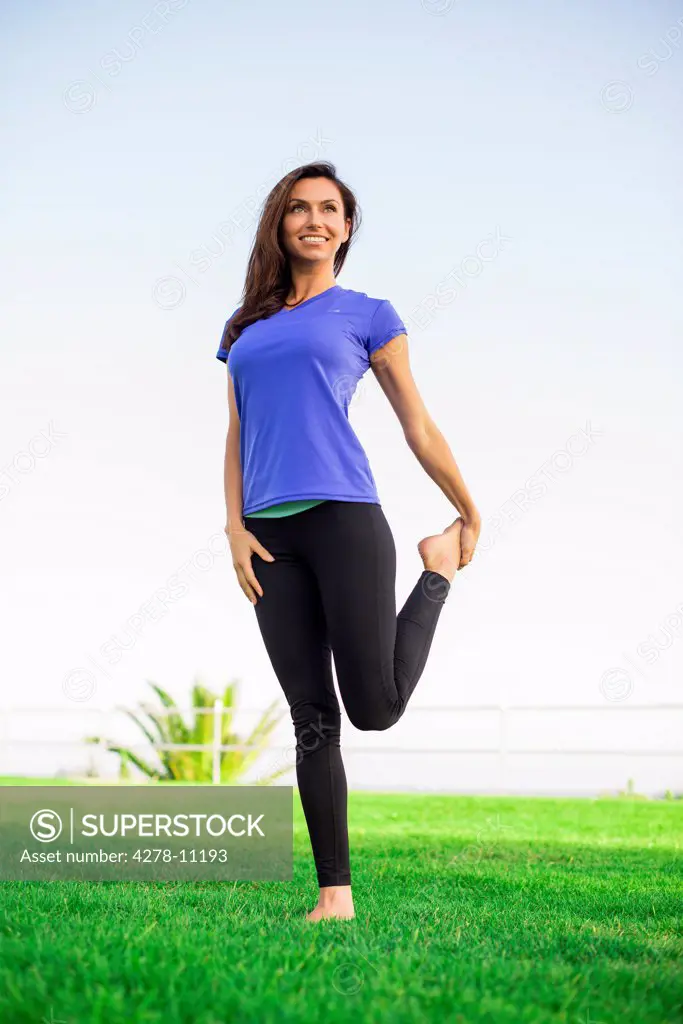 Woman Standing on Grass Stretching her Leg