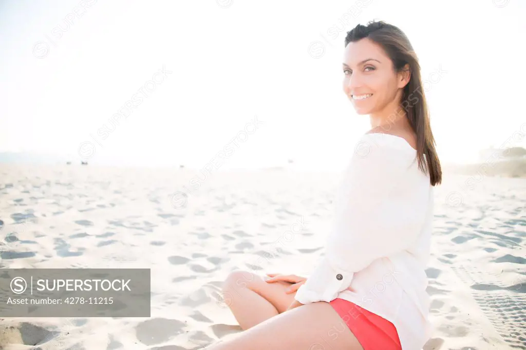 Smiling Woman Sitting on Sand