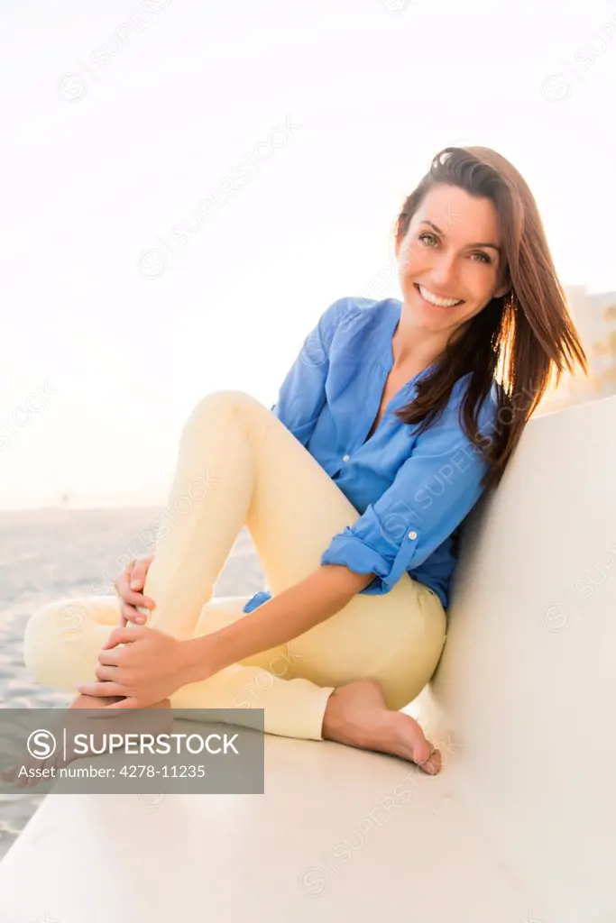 Smiling Woman Sitting on Beach Bench