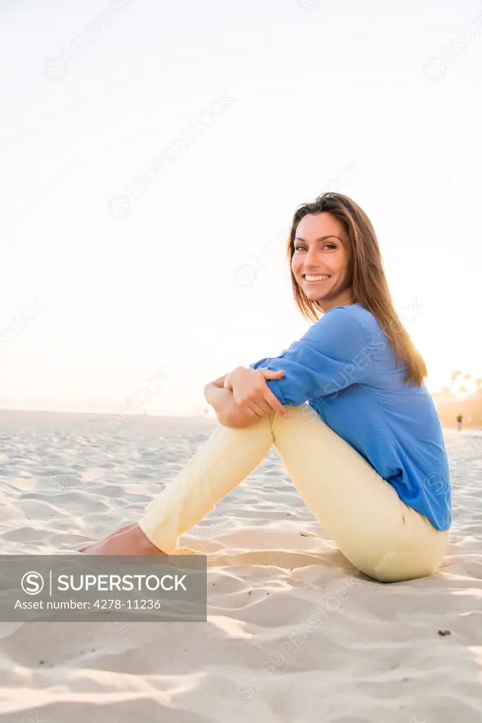 Smiling Woman Sitting on Sand