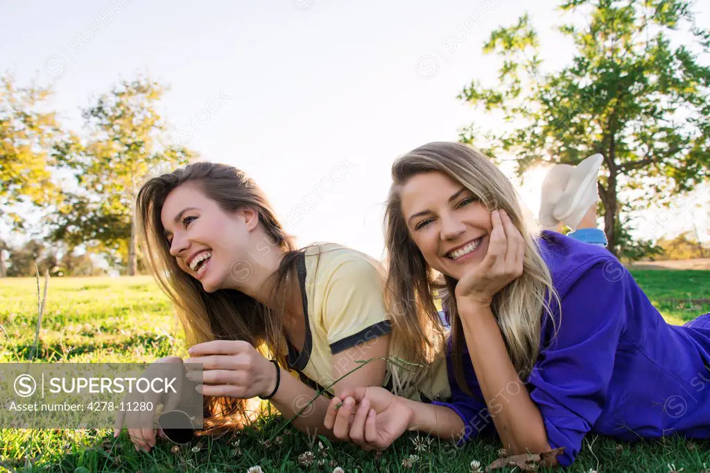 Two Women Lying on Grass Smiling