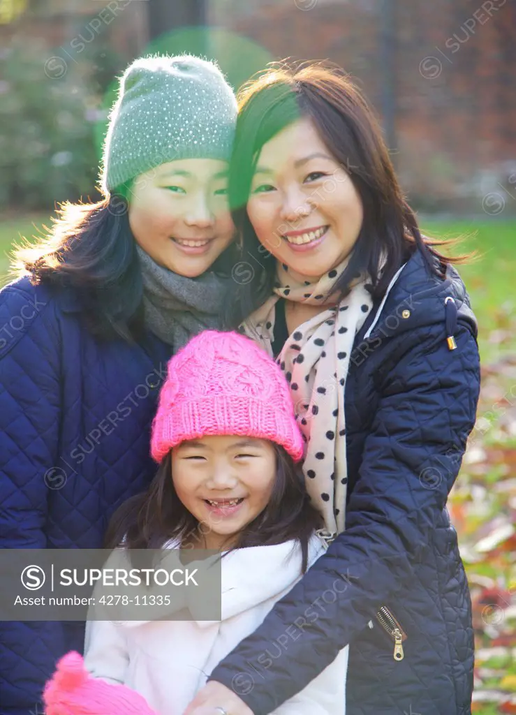 Mother and her Daughters Smiling Outdoors