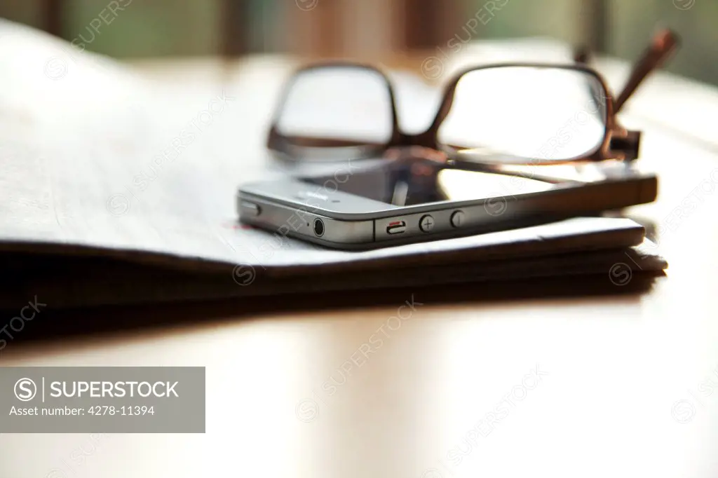 Eyeglasses and Smartphone on Folded Newspaper