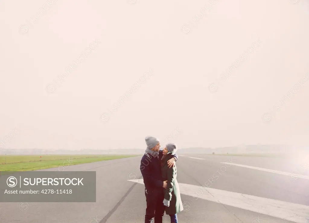 Couple Embracing on Airport Runway
