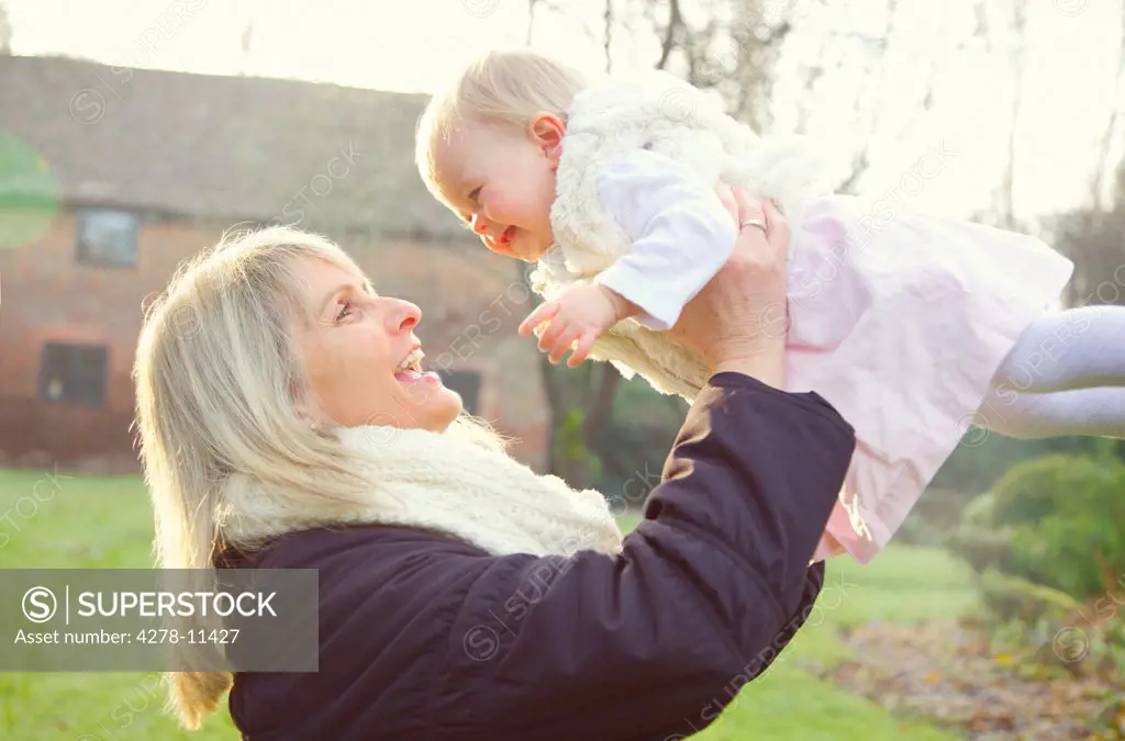 Mother Lifting Baby Daughter Outdoors