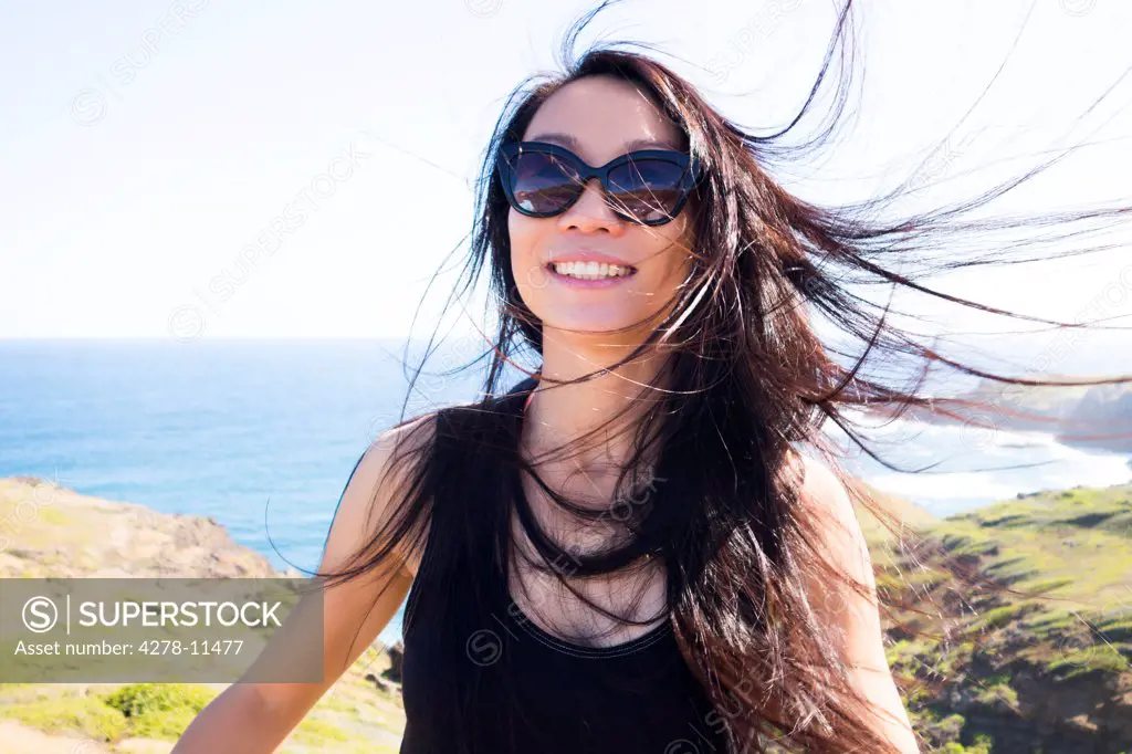 Smiling Woman on Hilltop with Windswept Hair