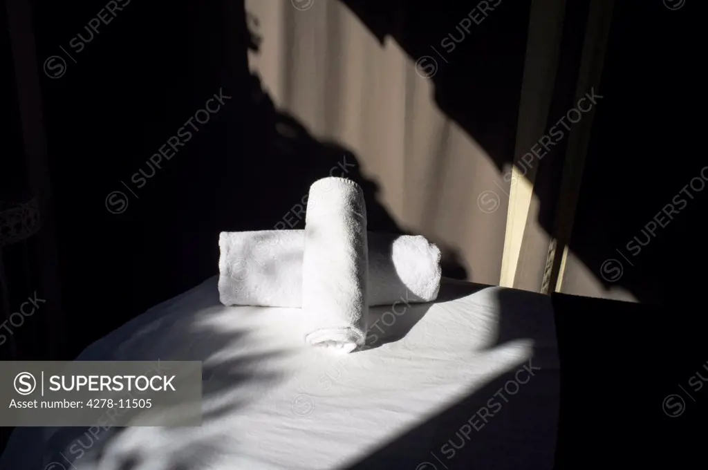 Empty Massage Table with Rolled up Towels, Close-up view
