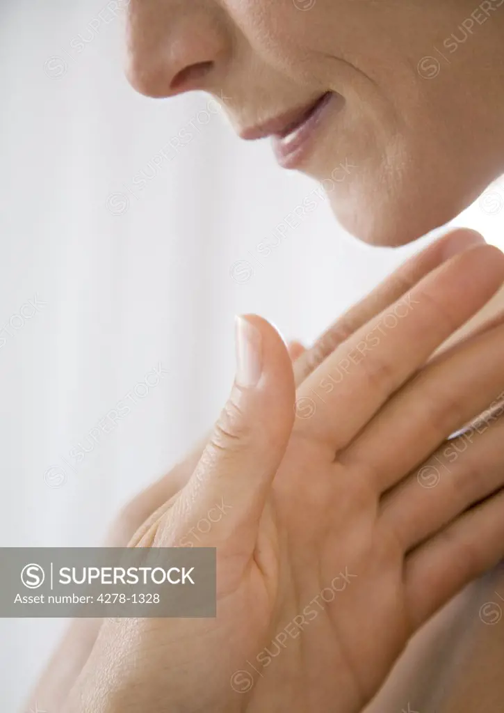 Extreme close up of woman's hands resting under face