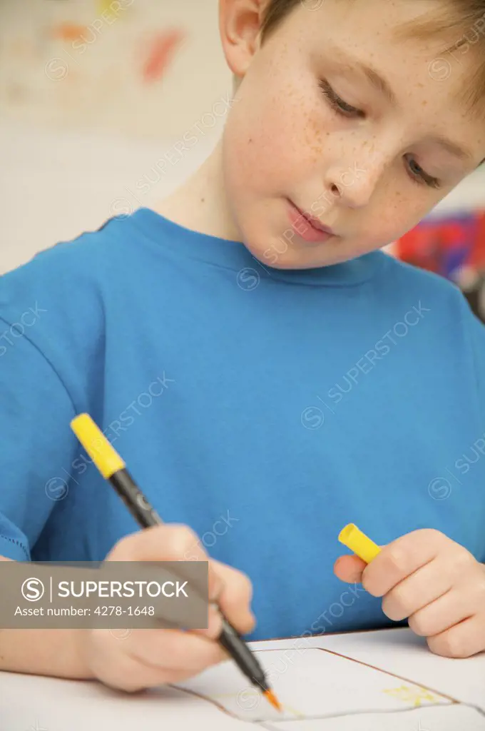 Portrait of a boy coloring with pen