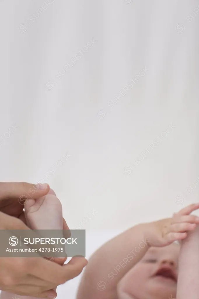 Close  up of woman's hand holding baby's foot