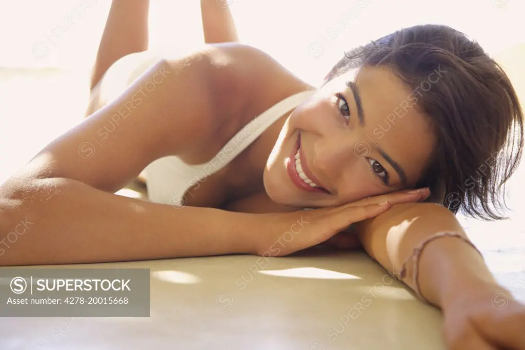 Young Woman Wearing Bikini Lying Outdoors, Close-up View