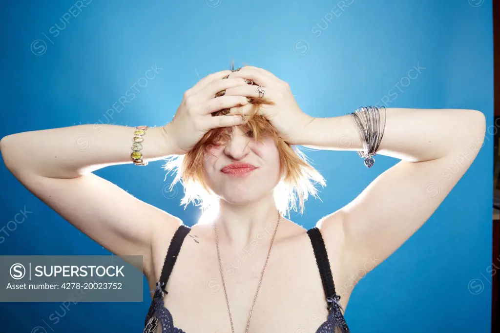 Young Woman with Hands on Head Grimacing