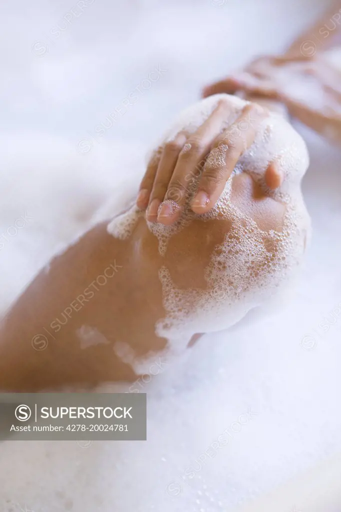 Woman in Bubble Bath, Close-up View of Knee and Hands