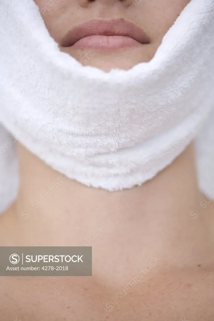 Close up of young woman having facial with towel covering chin