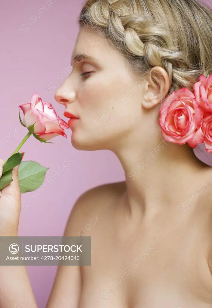 Profile of Young Woman with Braided Hair Smelling Rose