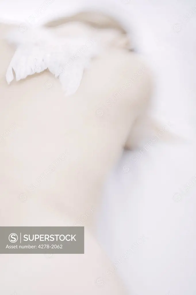 White feather wings on woman shoulders