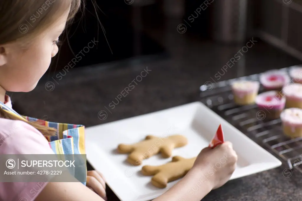Close up of girl decorating ginger bread man