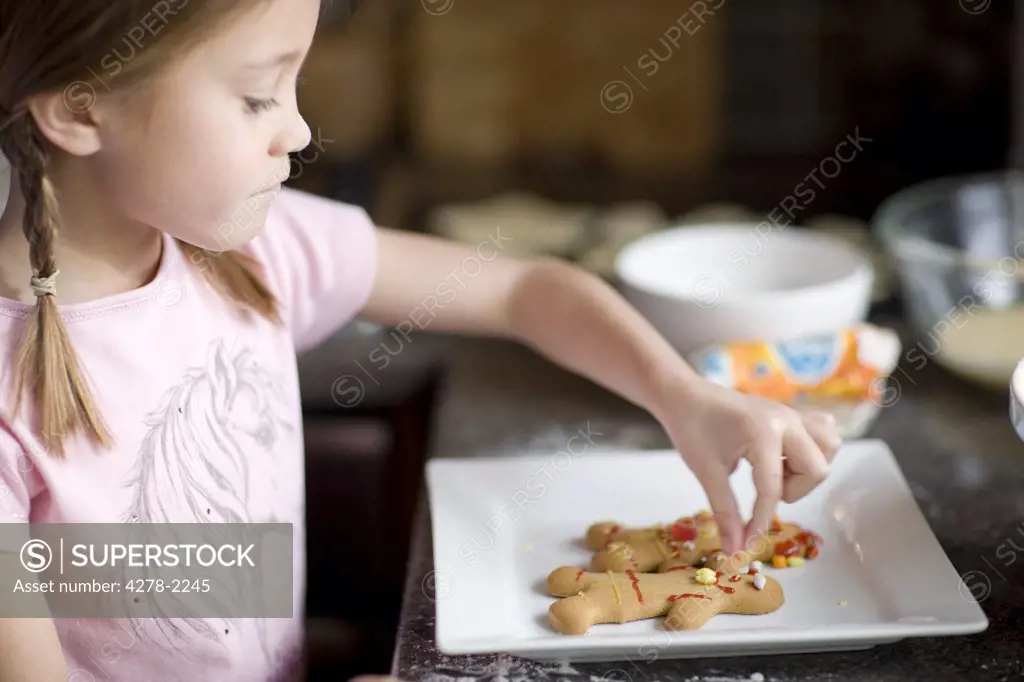 Young girl decorating ginger bread man