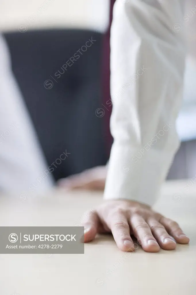 Close up of businessman's hands leaning on desk