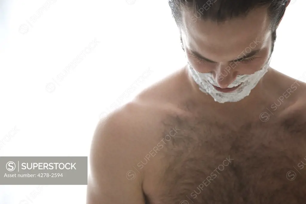 Close up of a young man with shaving cream on the face