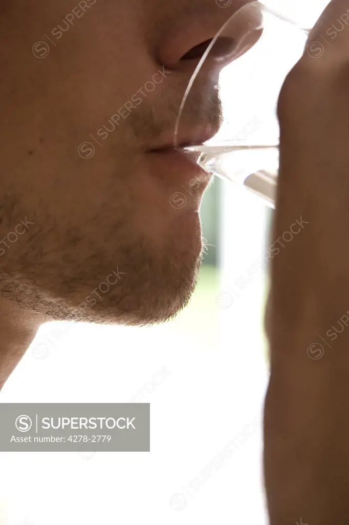 Close up of young man mouth drinking water