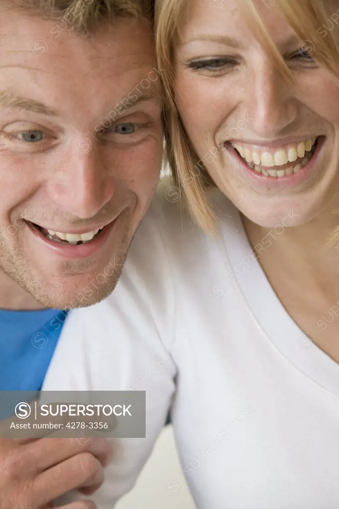 Close up of a couple looking down and laughing