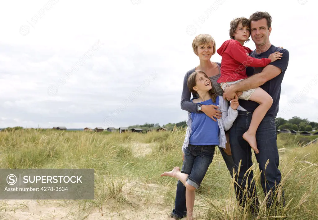 Portrait of family standing on a beach smiling