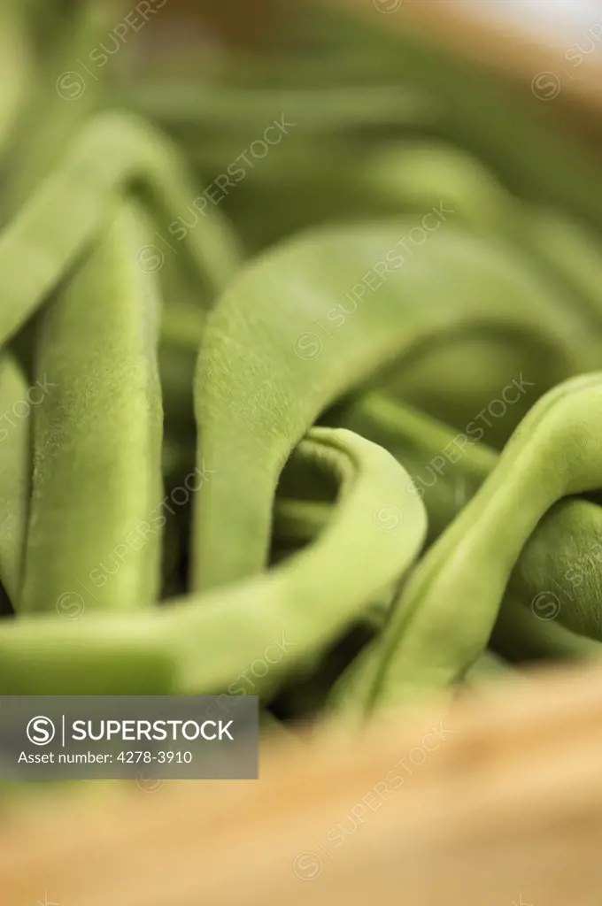 Extreme close up of broad bean pods in a wooden crate
